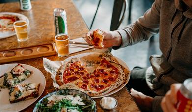 a table with plates of pizza and salad