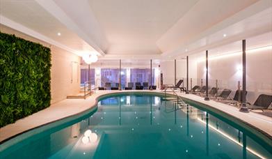 indoor swimming pool with lounger seating all around