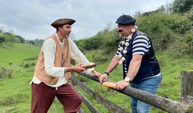 two men in historic costume talking to eachother