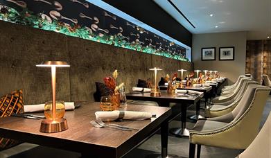 a low angle shot of the dining room at Reflections, showing small table lamps and tables set for dinner.