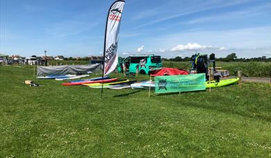 paddleboards laid out on the grass at Ferring ready for hire