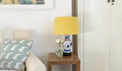 Yellow lamp positioned on top of a wooden side table in a living area