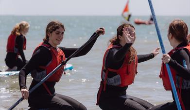 three women having fun on a paddleboard