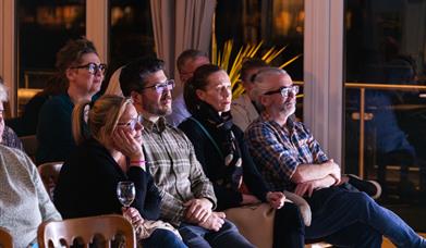people sitting in an audience watching attentively