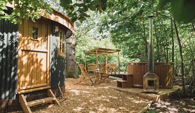 The Roundhouse: a woodland cabin for couples, with pretty outdoor covered dining deck, firepit and wood fired hot tub