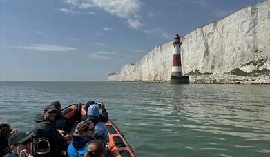 View of beachy head lighthouse from the water in a rib boat