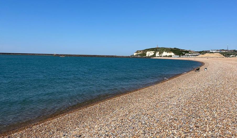 curved shoreline of tidesmill beach with cliffs in the background