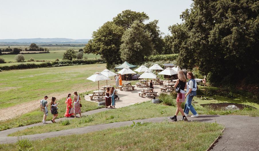 outdoor seating over looking green fields and people strolling