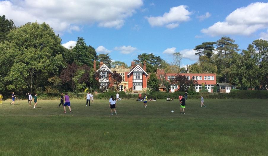view of the hall from the garden with young people playing football