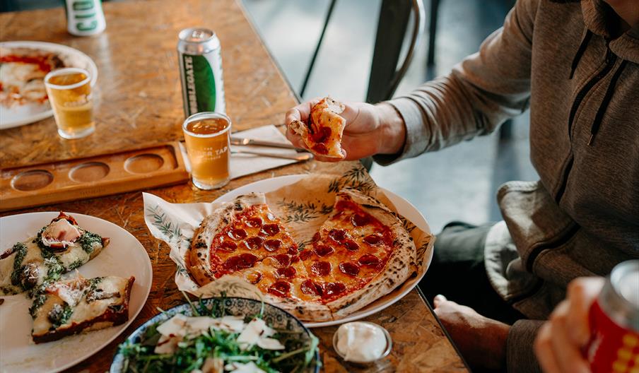 a table with plates of pizza and salad