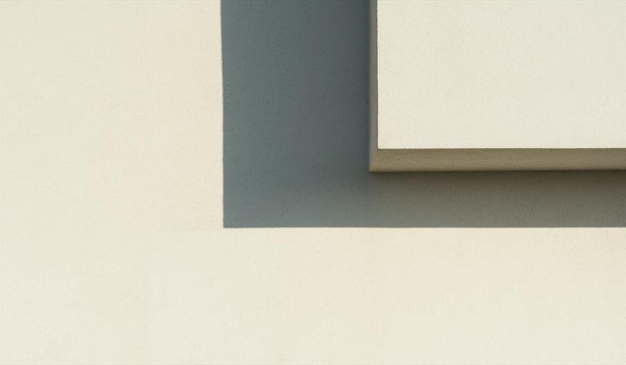 Minimalist image of geometric shadows on a white wall