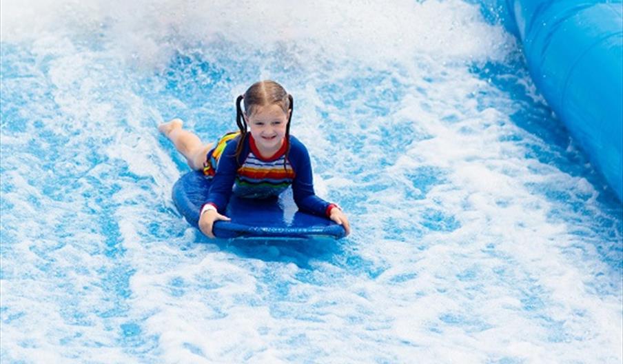 child playing on the surf machine