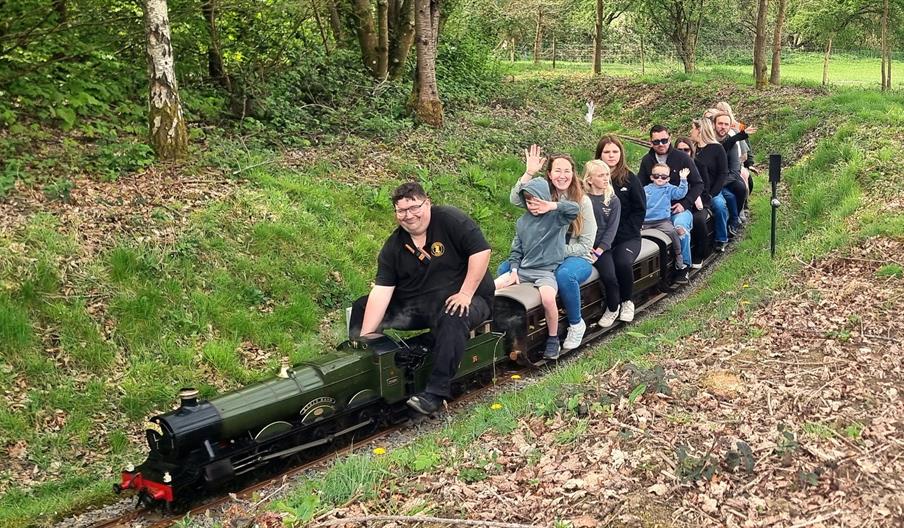 people riding a minature train