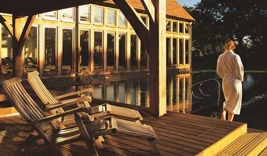 view of the outdoor swimming pool with a woman in a spa robe view the scene