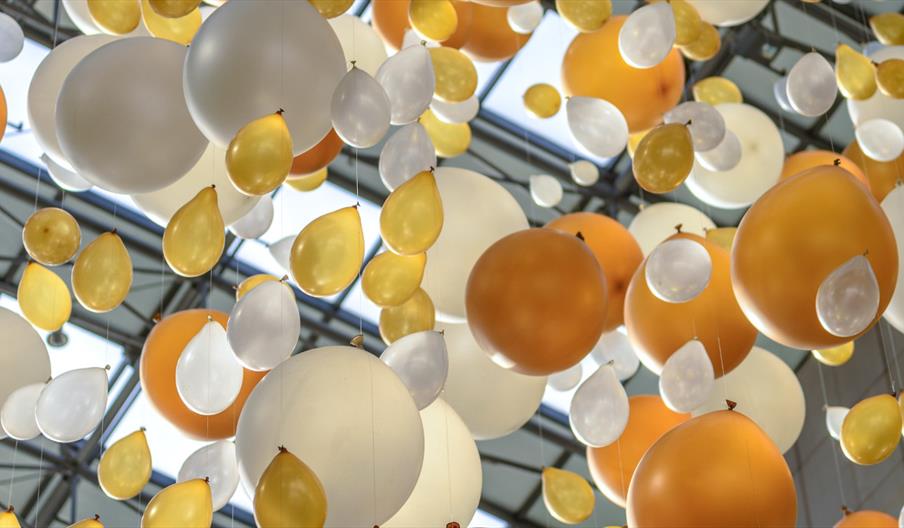 White and gold balloons tied to a string