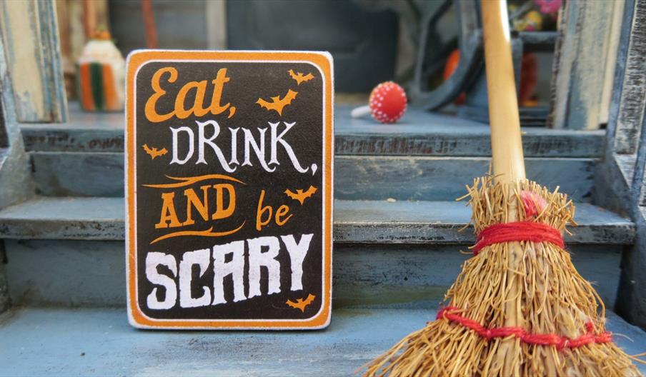Eat drink and be scary sign with wooden broom