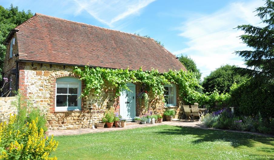 a sunny day view of the outside of a rural cottage