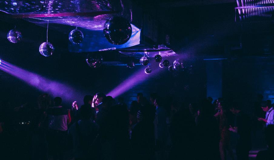 People dancing in purple club