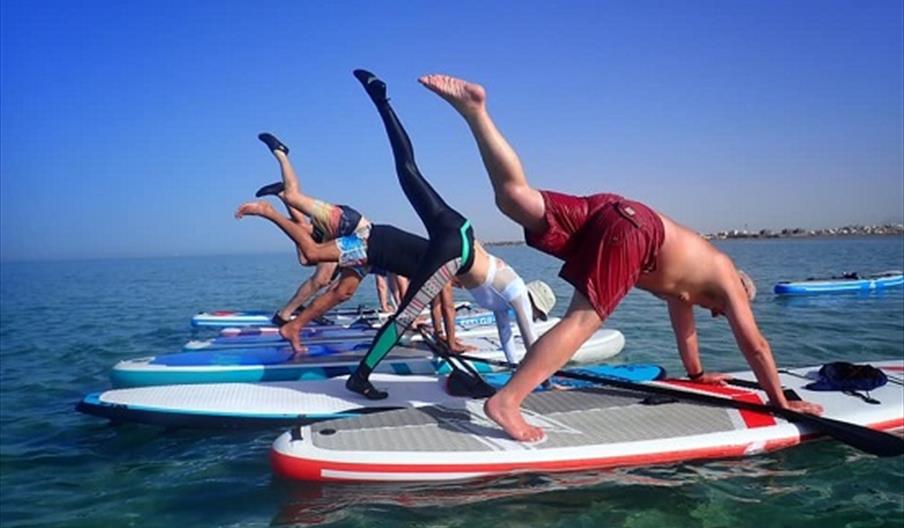 people doing yoga on paddleboards