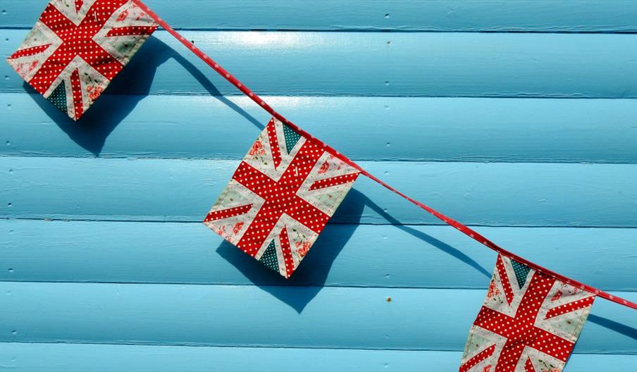 Bunting of the UKs flag against a light blue wall