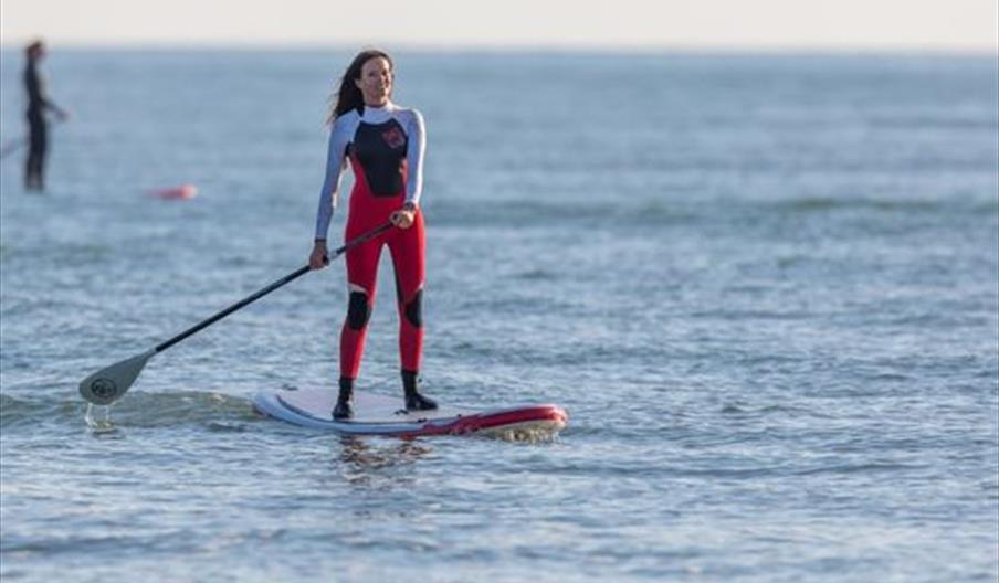 woman standing on a paddle board on the sea