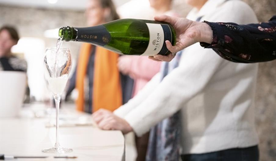 Close up of a bottle of Wiston Estate sparkling wine being poured into a glass