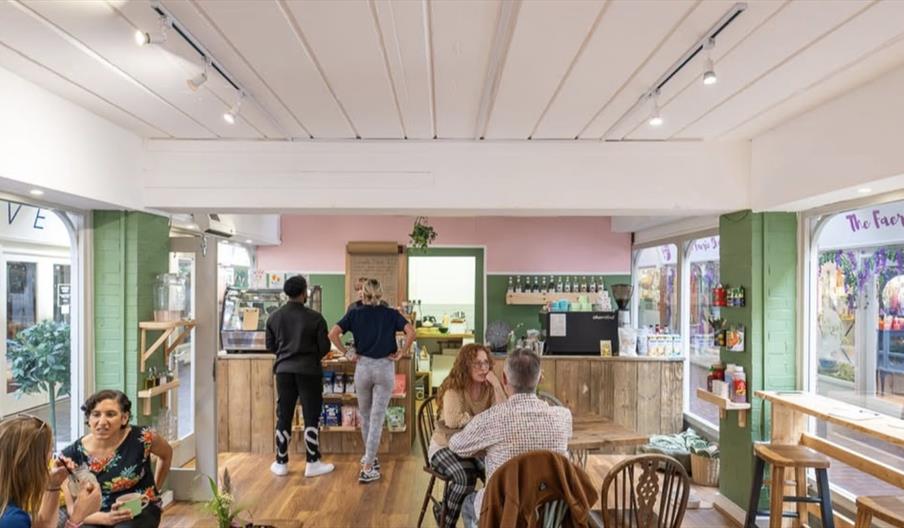 The inside of The Grub Club vegan cafe with people sitting enjoying their food and drinks