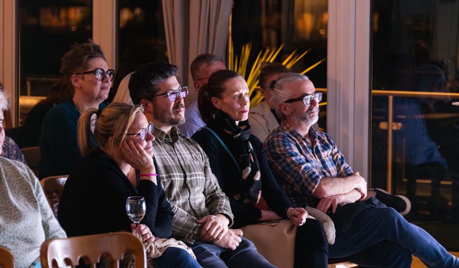people sitting in an audience watching attentively