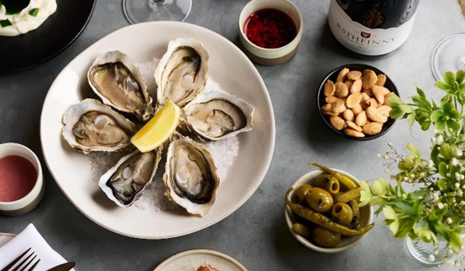 oysters and sharing bowls of with a bottle of wine