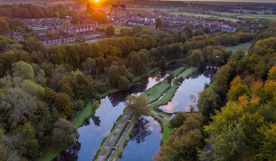 Aerial view of Chalk Farm trout fishery lakes with views of Arundel Cathedral and Castle in the background.