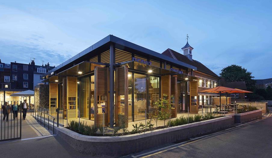 exterior photo of The Depot at dusk, with warm lights glowing from within