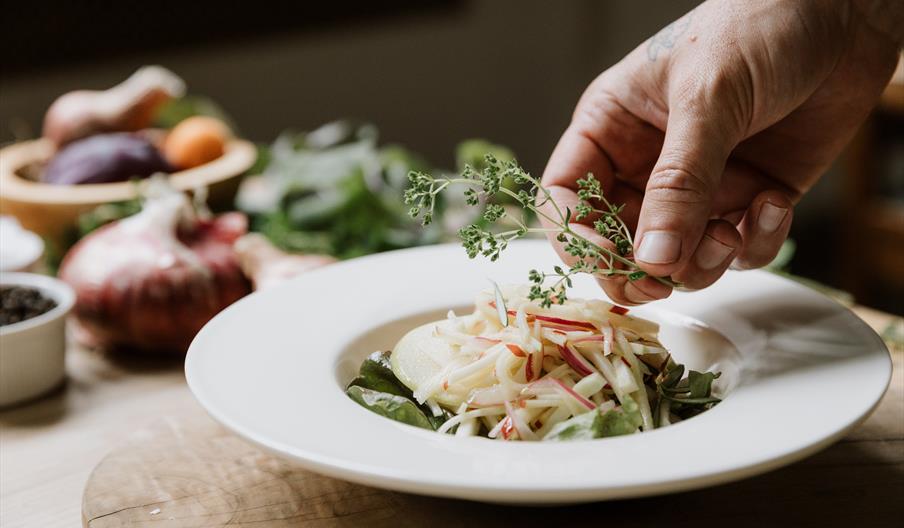 A plate of food being garnished