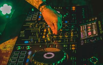 Electric mixing decks being operated by person with tattoos