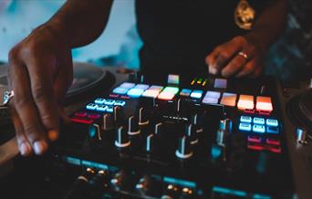 DJ using a turntable with multicoloured lights