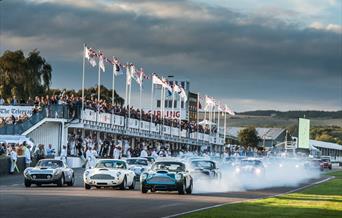 cars coming around the goodwood racing track
