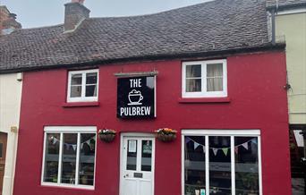 the red building with the sign The PulBrew