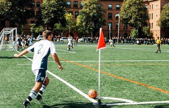 Man playing in a football match doing a corner kick