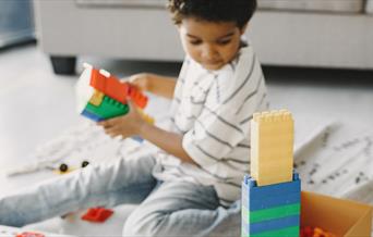 A child playing with colourful plastic building bricks
