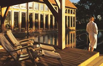 view of the outdoor swimming pool with a woman in a spa robe view the scene