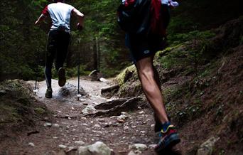Two people running on a trail