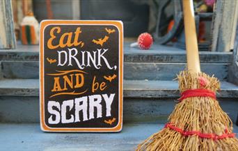 Eat drink and be scary sign with wooden broom