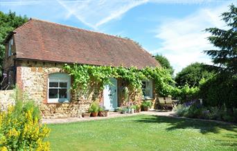 a sunny day view of the outside of a rural cottage