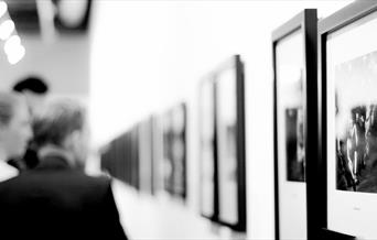 People looking at art on a wall