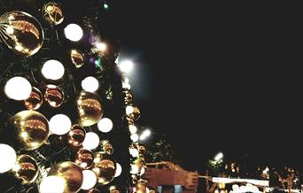 Gold and silver baubles displayed on the wall of an outdoor display