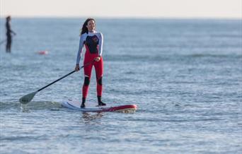 woman standing on a paddle board on the sea