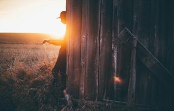 Person playing an acoustic guitar in the sunset