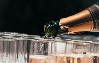 Champagne bottle pouring into glasses