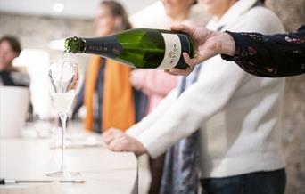 Close up of a bottle of Wiston Estate sparkling wine being poured into a glass