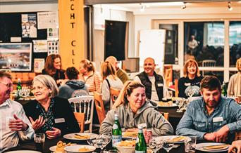 people at a event sitting at tables with food