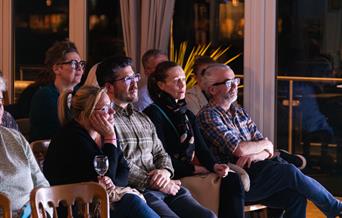 people sitting in an audience watching attentively